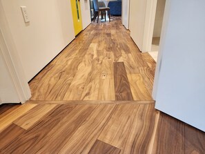 Ein Flur mit Holzboden und einer gelben Tür.
