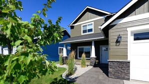 A residential house with a two-story design, a front porch, and a stone foundation. - Coeur d'Alene Hideaway 4 Bedroom Modern Mid Term Rental (Coeur d'Alene)