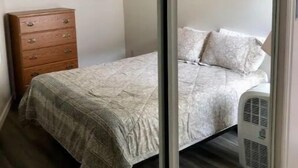 A bedroom with a bed, a dresser, a wall-mounted light, and a radiator. - #108 Condo near large pool & shuttle to Gorge Amp-book separately (Quincy)
