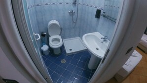 A bathroom with a toilet, bidet, sink, and shower. - Hostel Kanina (Sarandë)
