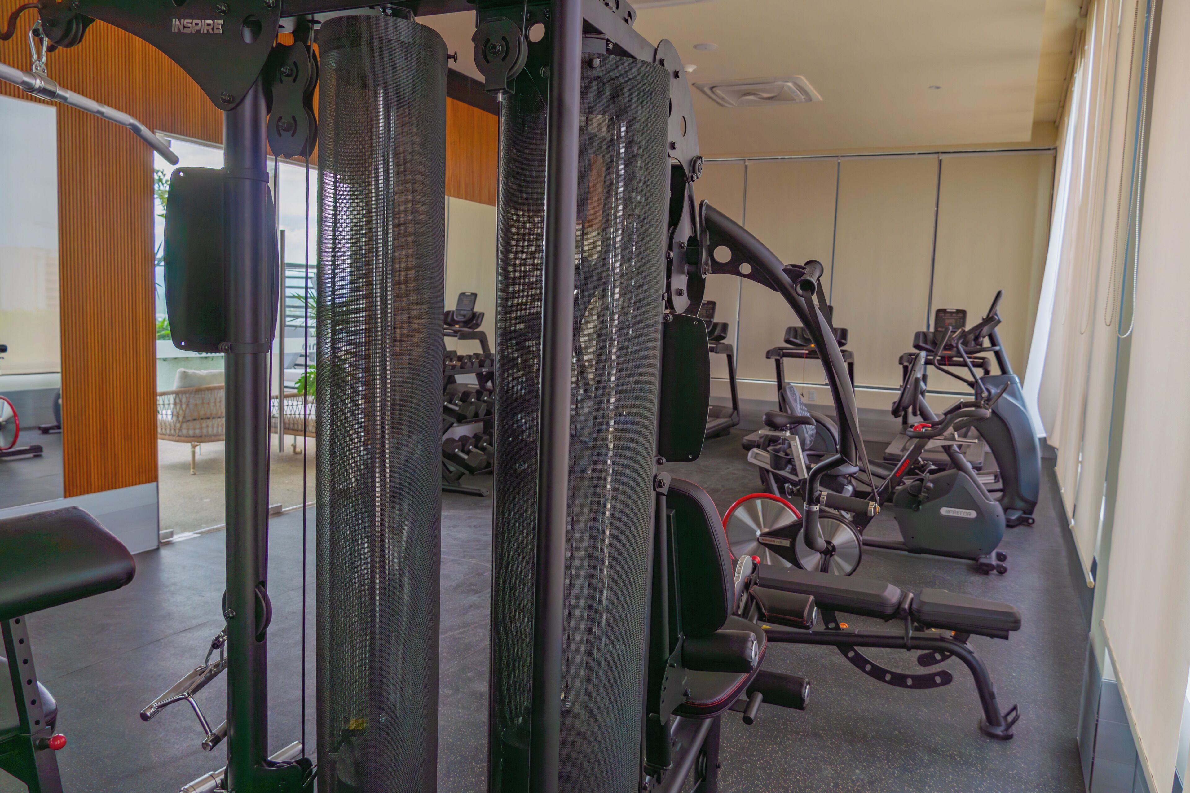 Une salle de sport équipée de matériel d’exercice, notamment un support à squats et des appareils de cardio.