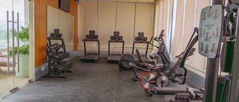 A gym with treadmills, elliptical machines, and weight machines.