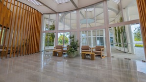 A spacious lobby with a high ceiling, large windows, and a central seating area with chairs and a small table. - Hotel Mio Riviera Nayarit - Adults Only (Nuevo Nayarit)