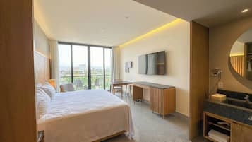 Une chambre d’hôtel avec un lit, un bureau et une salle de bain.
