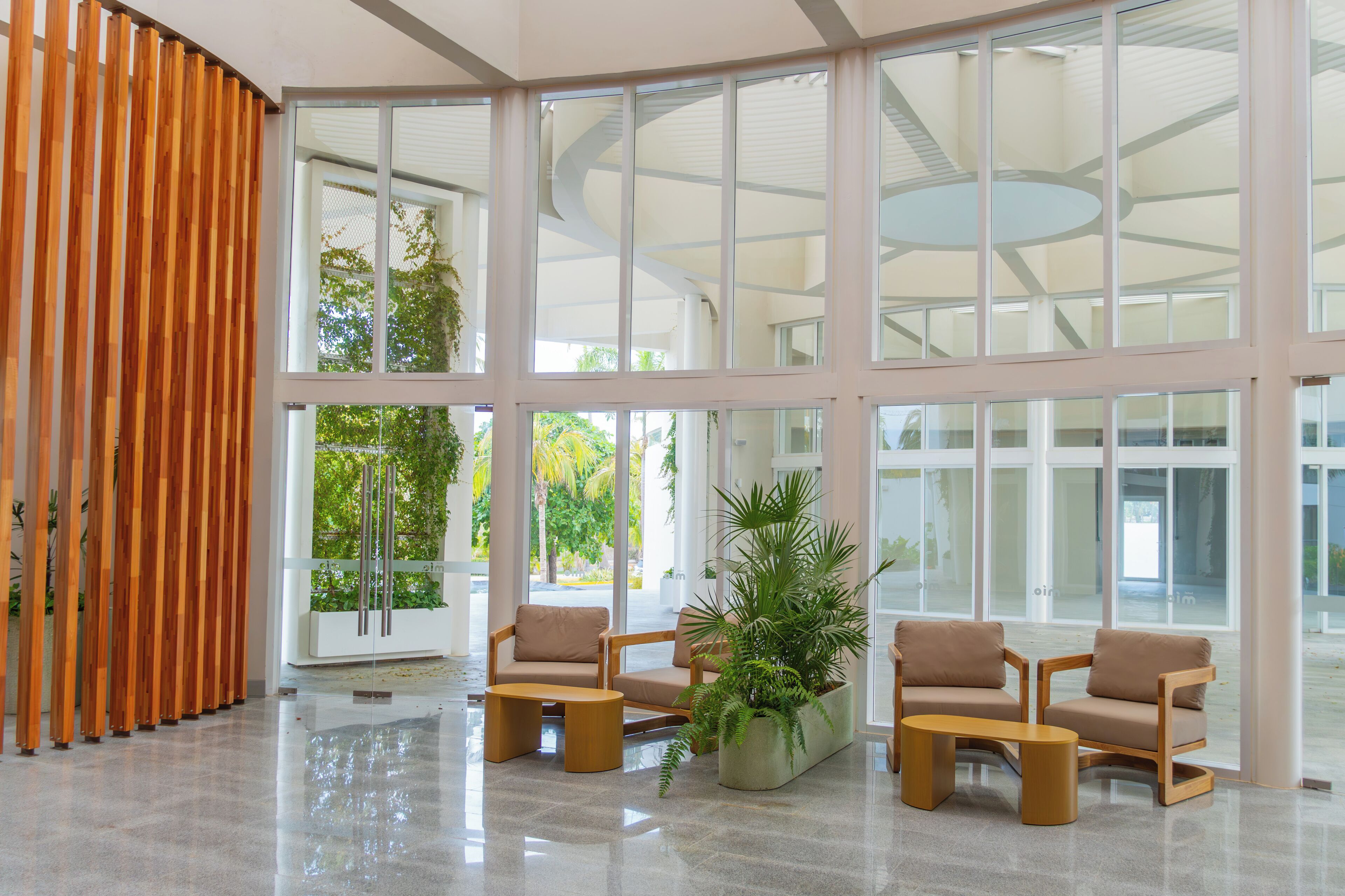 A spacious lobby with high ceilings, large windows, and a modern interior design.