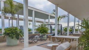 A rooftop lounge area with lounge chairs, a table, and potted plants. - Hotel Mio Riviera Nayarit - Adults Only (Nuevo Nayarit)