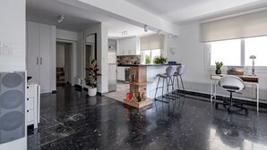 A modern kitchen with white cabinets, a wooden island, and a bar area. - The Black Marble - Sea View / 2BR / 1,5BA (Paleo Faliro)