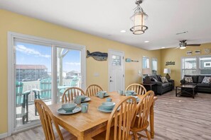 Relax in this inviting living space with a dining table for four, sliding glass door to a balcony, and comfortable seating area.