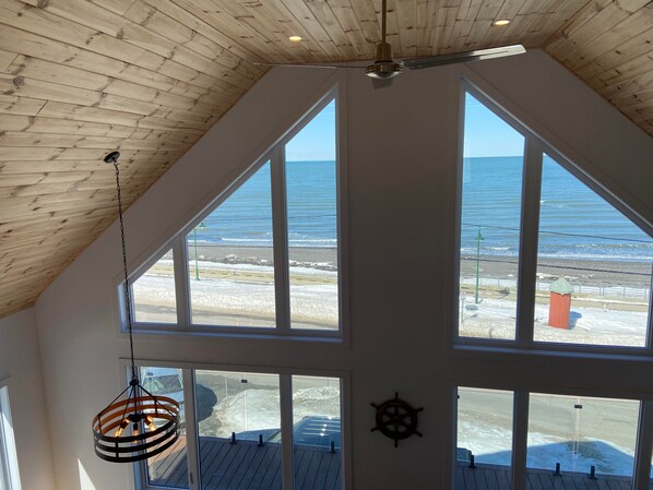 Habitación con techos altos y amplios ventanales con vista a la playa.