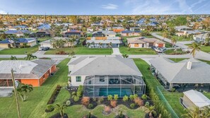 Et boligområde med huse, en swimmingpool og velplejede græsplæner.