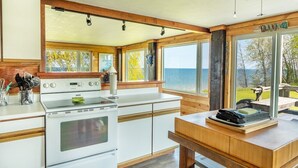 A modern kitchen with a large window overlooking a scenic view. - Lakeview Retreat near Green Bay, Door County (Kewaunee)