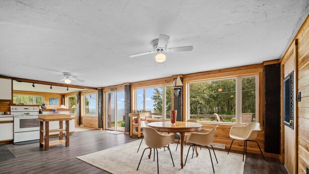 A spacious kitchen with wooden cabinets, a central island, and a dining area with a round table and chairs. - Lakeview Retreat near Green Bay, Door County (Kewaunee)