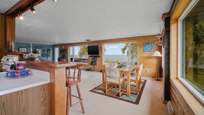 A spacious kitchen with wooden accents, a dining area with a view, and a large window overlooking the outdoors. - Lakeview Retreat near Green Bay, Door County (Kewaunee)