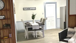 Un comedor con una mesa de madera, sillas y un letrero que dice "KITCHENS Bring families together."