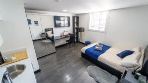 A modern hotel room with a bed, desk, and a large mirror. - Modern Studio Next to University of Birmingham (Birmingham)