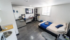 Quarto de hotel moderno com cama, escrivaninha e um espelho grande.