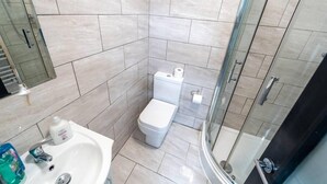 Ein modernes Badezimmer mit Toilette, Waschbecken und Duschbereich.