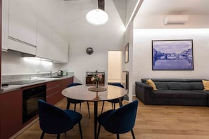 Une cuisine moderne avec un coin repas, un canapé et une œuvre d’art encadrée accrochée au mur.