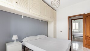 Ein Schlafzimmer mit Bett, Nachttisch und Kleiderschrank.