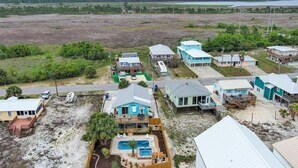 Una propiedad costera con varias casas, una piscina y una zona de playa.