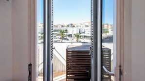 A balcony with a view of a cityscape, including buildings and palm trees. - Downtown Cannes, walk to Beaches and Croisette (Cannes)