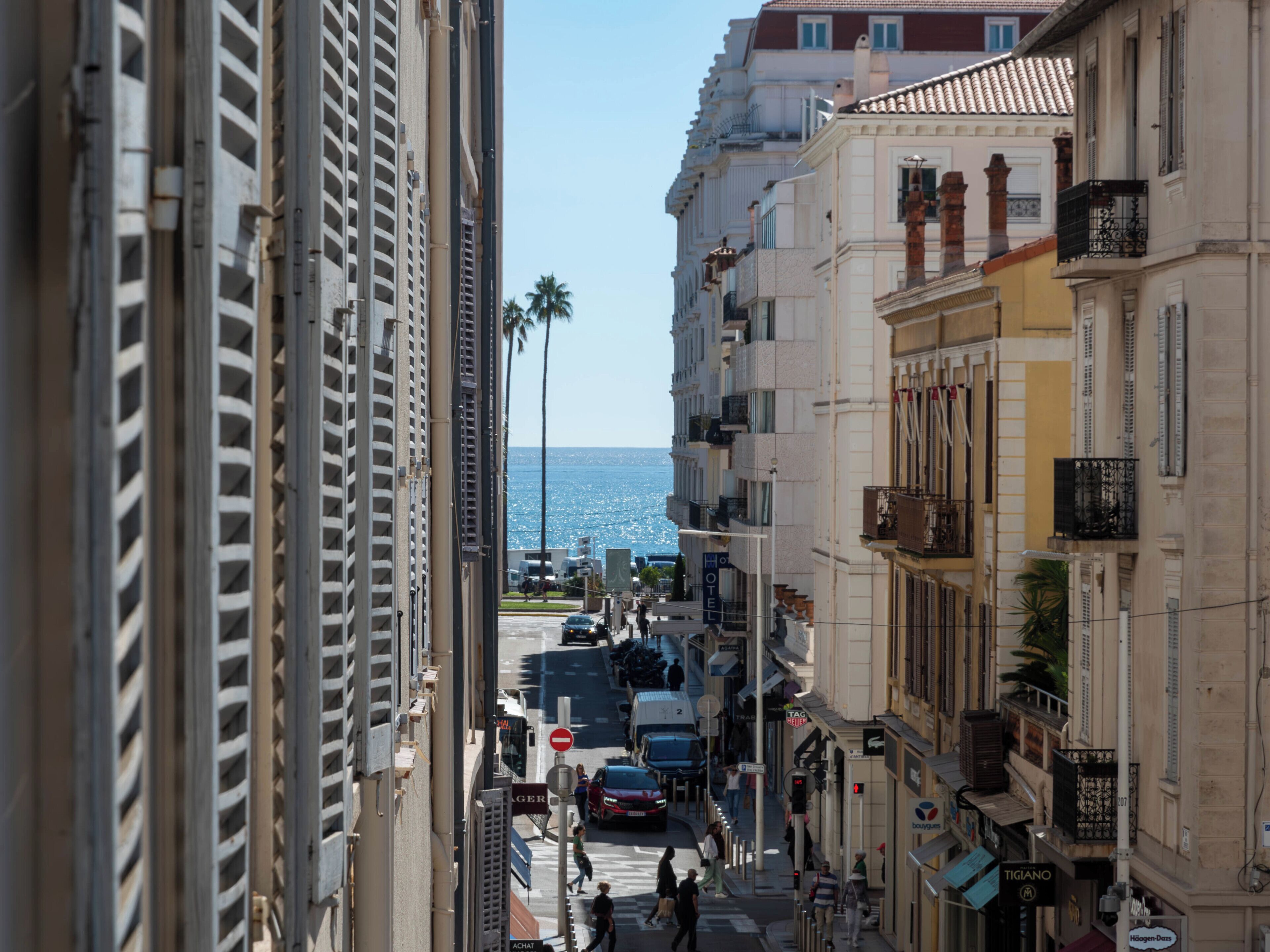 Una vista di una strada con edifici, cielo sereno e il mare sullo sfondo.
