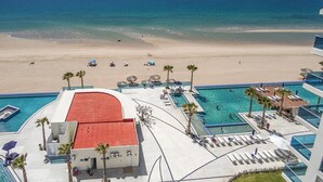 A resort with a pool, beach, and ocean view.