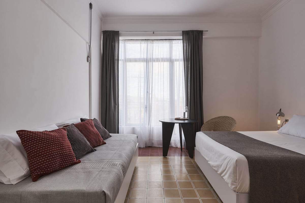 Une chambre d’hôtel avec deux lits, une petite table et une chaise.