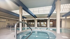 An indoor swimming pool with clear water, surrounded by lounge chairs and a covered roof structure. - Bluewater 1005 |  Beachfront Condo | Private Balcony | Resort Amenities | My Beach Getaways (Orange Beach)