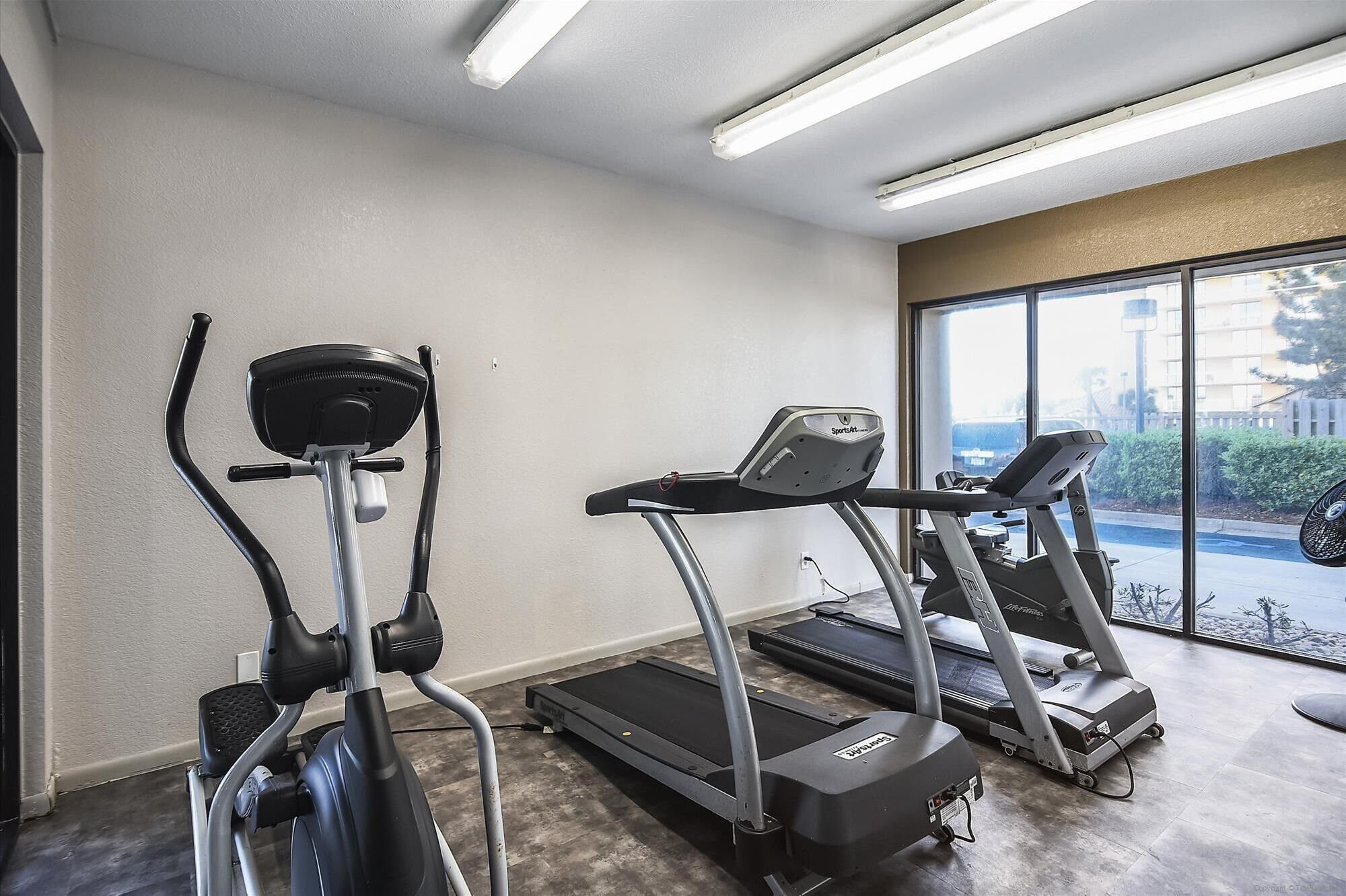 A gym with two treadmills and one elliptical machine.