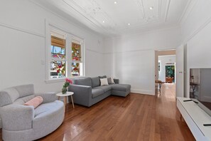 Relax in this stylish living room with a large sofa, armchair, and TV.