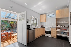 Enjoy cooking and dining al fresco in this kitchen with a stove, microwave, and dishwasher, plus ample storage and a patio area.