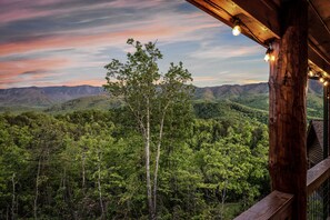 A view from a wooden balcony overlooking a forested mountain range. - Stunning Mountain View’s/Hot tub/Fire pit/Game room/Cabin Comfort (Gatlinburg)