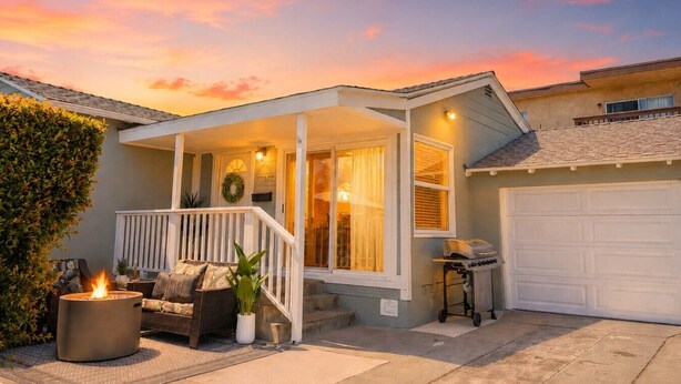 A house with a porch, a fire pit, a garage, and a well-maintained lawn. - Missouri St · 5 Mins to Beach! New 3bd Getaway / Central AC! (San Diego)