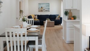 A modern interior with a dining area, a living room, and a kitchen. - Missouri St · 5 Mins to Beach! New 3bd Getaway / Central AC! (San Diego)