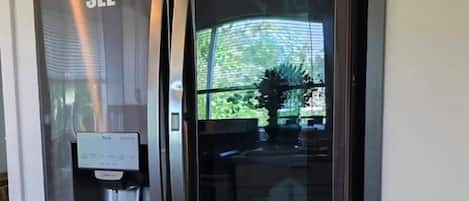 A stainless steel refrigerator with a water dispenser and a glass door.