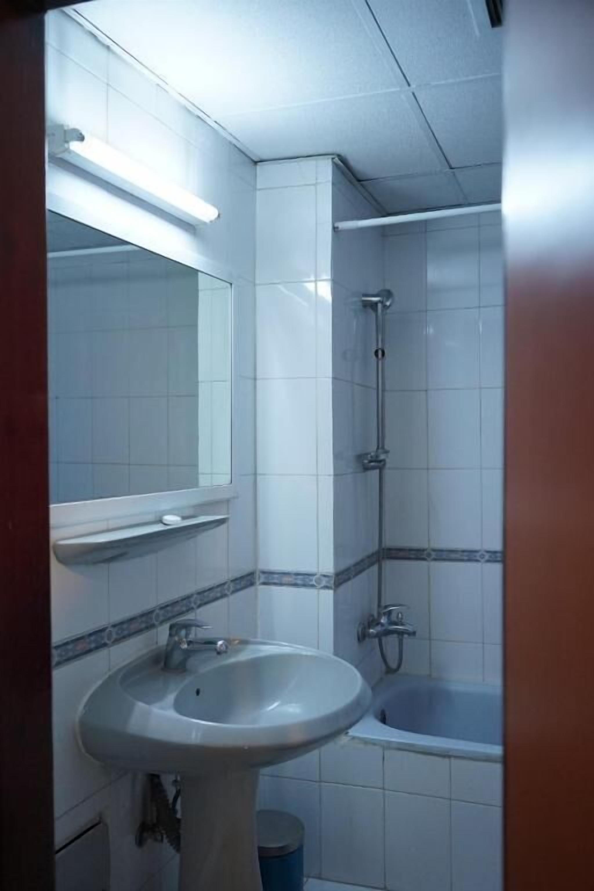Un baño con lavamanos, espejo, ducha y bañera.