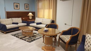 A living room with two sofas, a round coffee table, and two armchairs. - Concord hotel  (Amman)