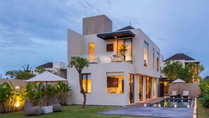A modern two-story house with a swimming pool, outdoor seating, and a well-maintained garden. - Svarga Pabean Villas (Sukawati)