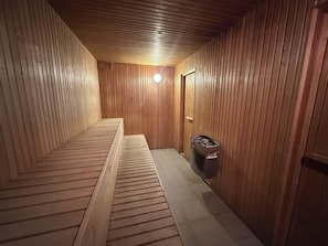 A sauna room with wooden walls and benches.