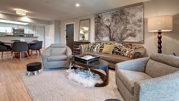 A modern living room with a sofa, armchairs, a coffee table, and a dining area with chairs and a table. - Charming & Comfy Condo in the Heart of Old Town! (Scottsdale)
