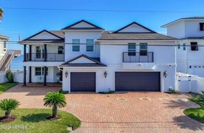 A two-story house with a garage, a balcony, and a well-maintained driveway.