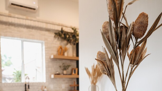 A dining table with plates, a vase with dried plants, and a basket of potatoes. - The Silo Inn near Zion, Snow Canyon and Bryce Canyon! honeymoon getaway. 2023 (Washington)