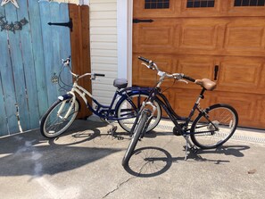 Duas bicicletas estacionadas em frente a uma porta de garagem.