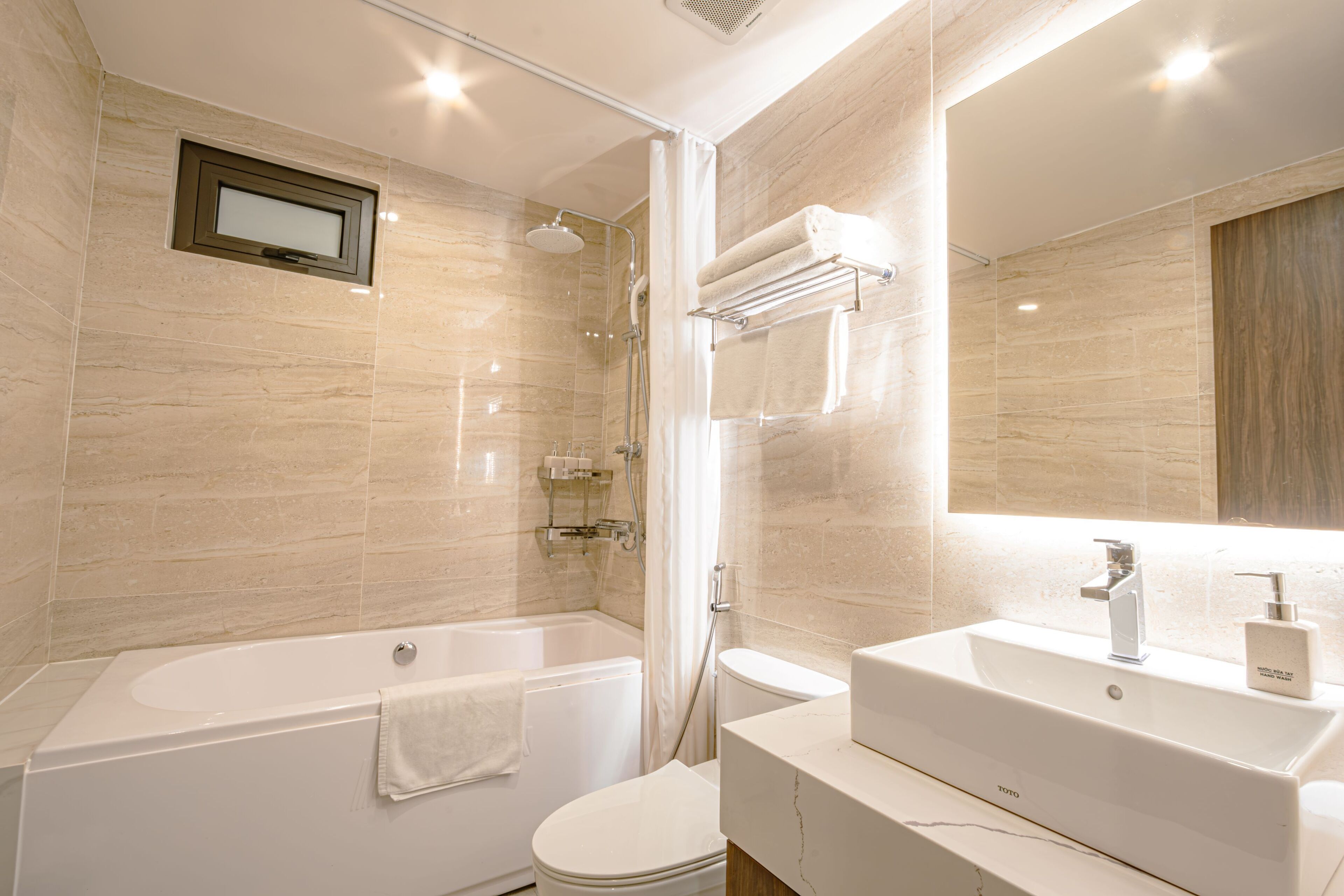 A modern bathroom with a bathtub, toilet, and sink.