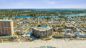 An aerial view of a coastal town with a large hotel complex, beachfront properties, and a marina. - Breathtaking views! 1 BR Gulf front condo w/2 pools on relaxing east side of PCB (Panama City Beach)