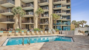 A hotel with a swimming pool, palm trees, and outdoor seating areas. - Breathtaking views! 1 BR Gulf front condo w/2 pools on relaxing east side of PCB (Panama City Beach)