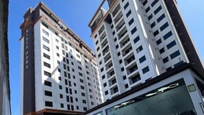 Un edificio alto con una piscina en primer plano.