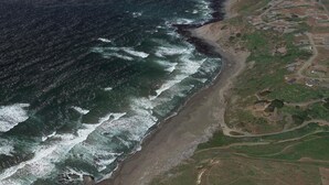 An aerial view of a coastal area with a beach, roads, and scattered buildings. - The ocean meets the meadow at the forest's edge. Private beach. Soak under stars (Manchester)