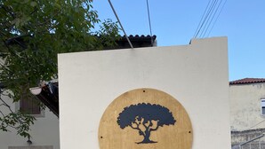 Opastekyltti, jossa on puun siluetti ja teksti: ”Walnut Tree Villa Archanes”.